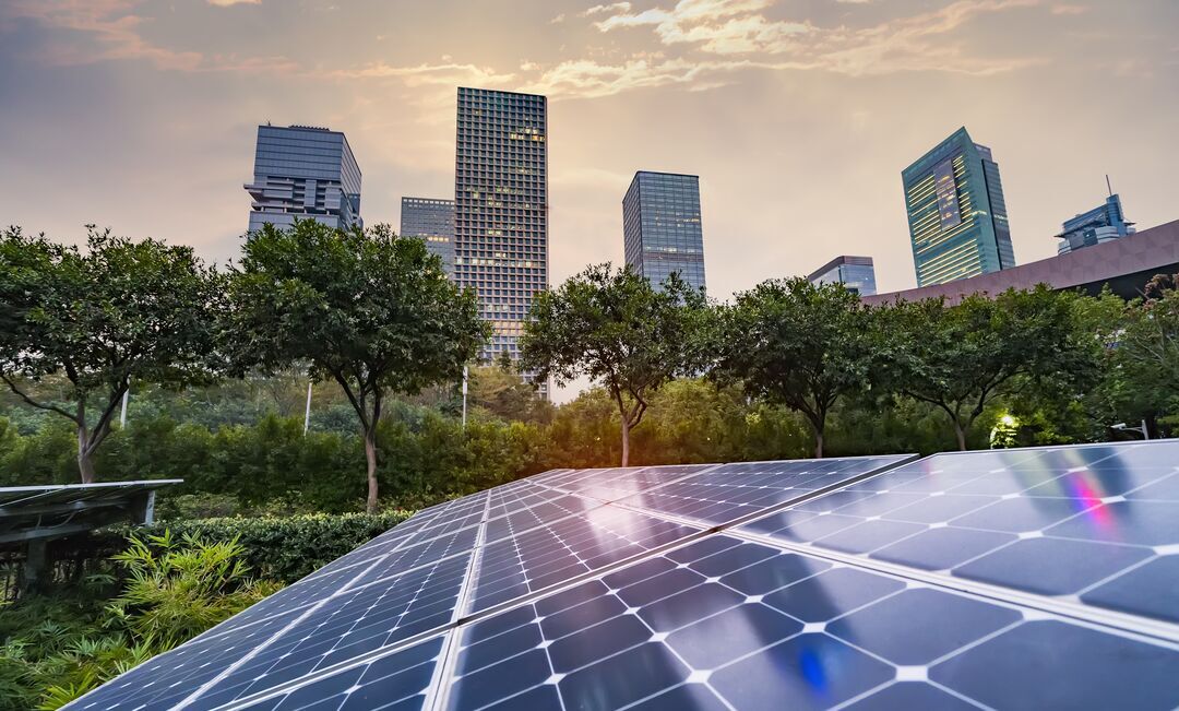 Web_Desktop-Ecological energy renewable solar panel plant with urban landscape landmarks