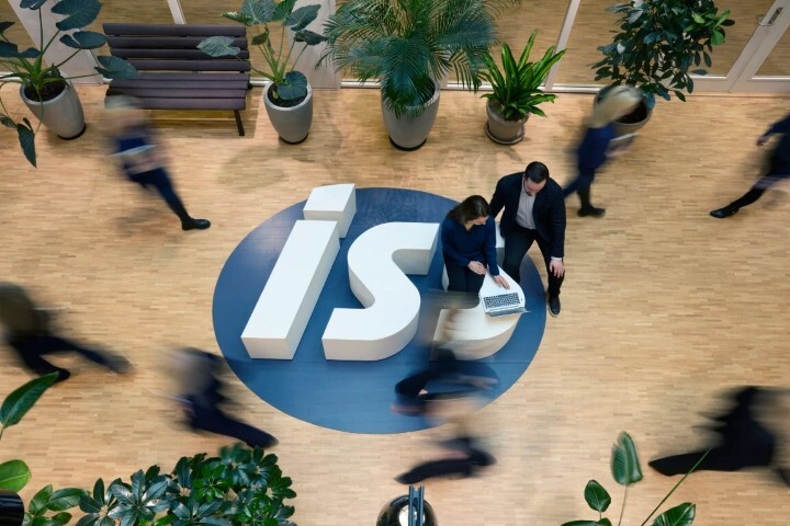 People moving around in an office with a large ISS logo